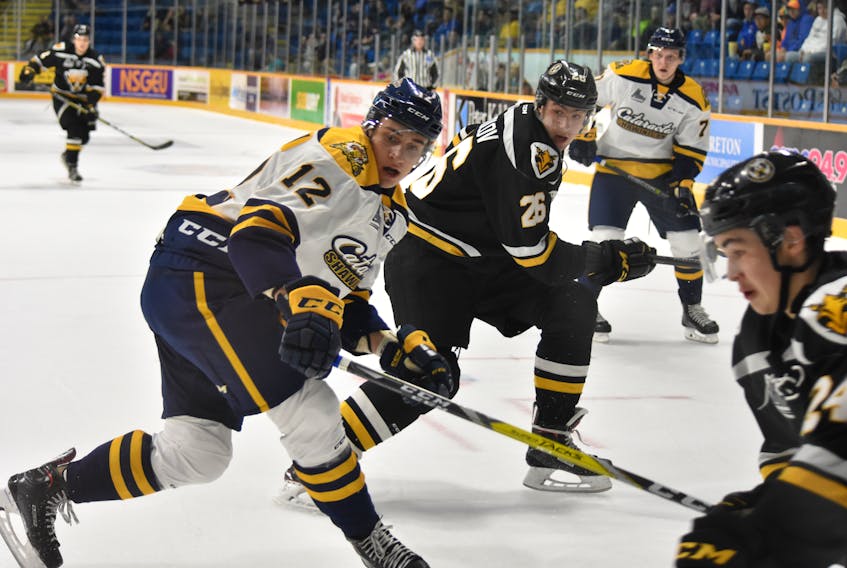 Egor Sokolov of the Cape Breton Screaming Eagles, middle, and Renat Dadadzhanov of the Shawinigan Cataractes watch the puck during he first period of Quebec Major Junior Hockey League action Thursday at Centre 200. Despite a late-game comeback, Cape Breton lost 7-6 in overtime. T.J. Colello/Cape Breton Post