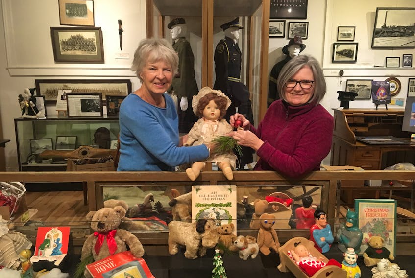 Elke Ibrahim, left, and Mary Ann McAdam hold two antique dolls that are part of the historic Christmas display at the Glace Bay Heritage Museum, located inside Old Town Hall on McKeen Street, Glace Bay. The women were preparing for the annual Old Town Christmas Bazaar taking place on Sunday.