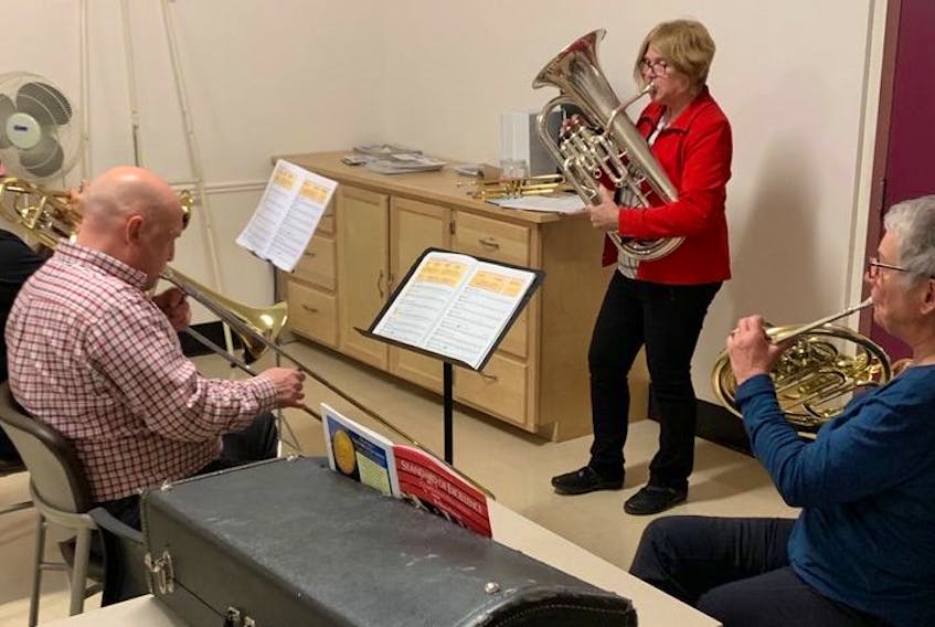 Brass specialist Margaret Miles, standing, instructs from left to right, Fred Tiley on trumpet, Glenn Turner on trombone and Elizabeth Buffett on French horn during a Music For Life session.