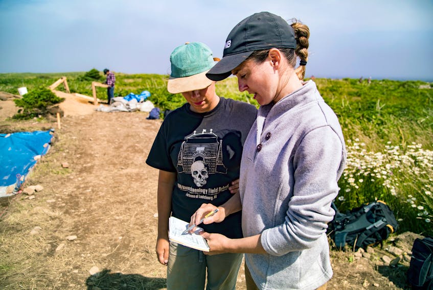 Dr. Amy Scott, right, goes over some notes with UNB graduate student Nicole Hughes during excavation work at a cemetery located at the Fortress of Louisbourg. The dig is part of a partnership between Parks Canada and the University of New Brunswick to locate, analyse and re-locate human remains found in the graveyard that is threatened by coastal erosion.