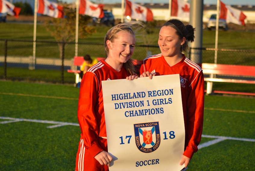 Captains of the Riverview Reds Division 1 girls soccer team, Taylor Coleman, left, and Lindsey Ripley, hold the Highland Region Division 1 girls banner after they defeated the Sydney Academy Wildcats 9-1 at Open Hearth Park in Sydney on Friday. CHRISTIAN ROACH/CAPE BRETON POST