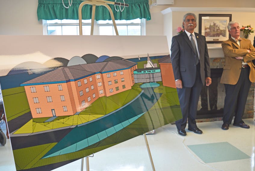 Chair of the Community Lodge Housing Society, Cecil Abel, left, and past chair, Carl Rideout, stand next to an illustration of what the new 50-unit apartment complex will look like when completed. ERIN POTTIE/CAPE BRETON POST