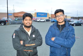 Cape Breton University students Kevin Antony, 23, left and Noby Varghese, 23, both originally from India and now living in Sydney, outside Walmart in Sydney. Varghese has searched for employment since arriving in May and Antony, since arriving in September. Needing funds for expenses, the two have started a service where they will pick up groceries or other products and deliver them. The men say they began two weeks ago but as of Wednesday only had one call that ended up cancelling.
