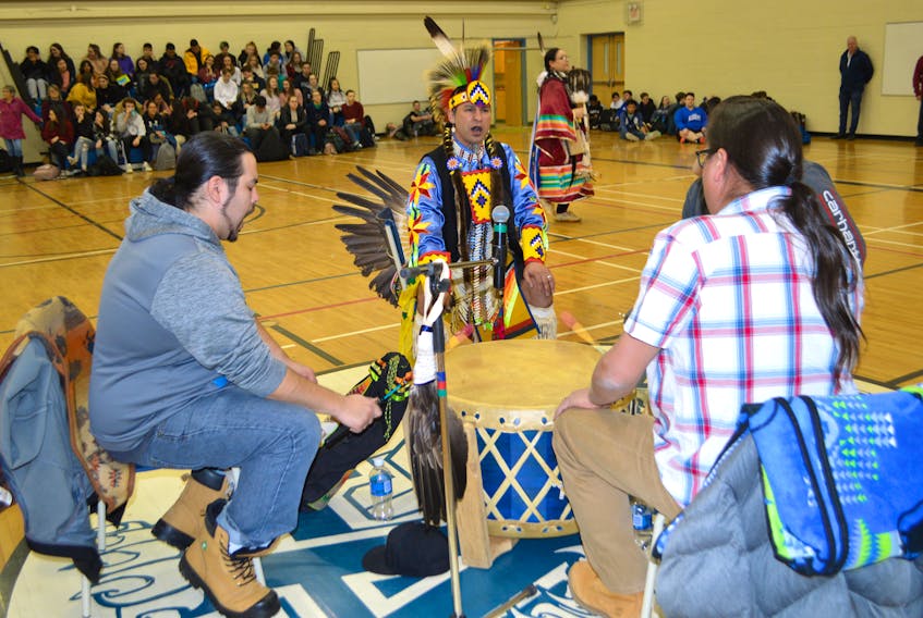 Members of the Stoney Bear Singers from Eskasoni including from left, Cyril Julian, Bill Meuse, Sulian Denny and Michael R. Denny, perform a song to honour women while Claire Meuse of Membertou, in background, performs a native woman’s traditional dance during the Mi’kmaq Cultural Day at Sydney Academy Friday.