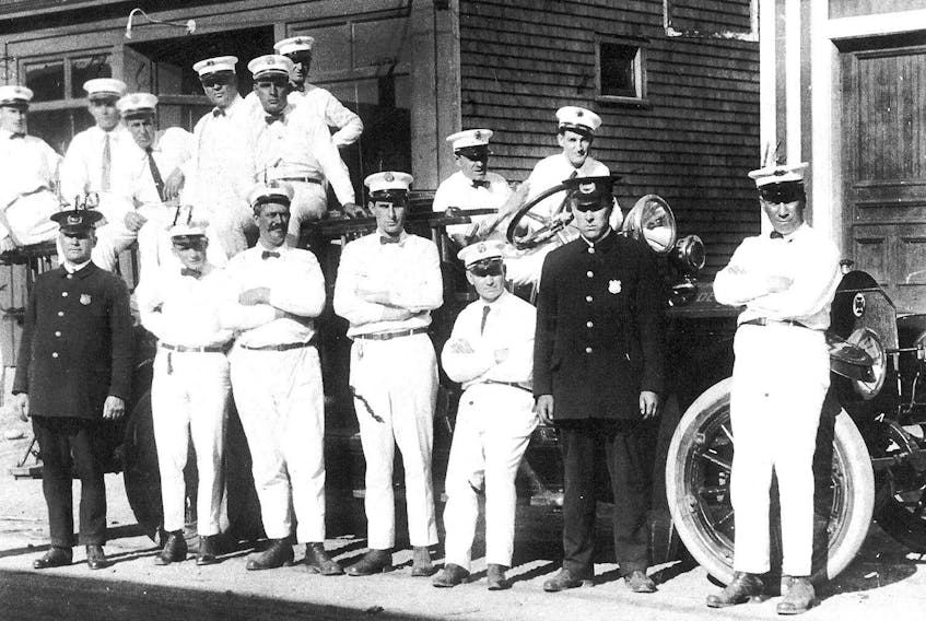 The New Waterford Volunteer Fire Department formed in 1916. Members of the department are shown standing in front of the town's first ever fire truck. Not in order, Lloyd Weatherbee, P.G. Muise, Hubert Muise, William G. Lewis (chief), Hughie MacNeil, Joe Roach, Arthur Burke, Lonnie Nearing, Harry Petrie, Dan N. MacNeil (policeman), Paddy Petrie, John R. McNeil, Jack Farrell, Billy Locke, Dannie Graham and James L. MacKinnon. Of note, the truck is parked in front Sadersky's Store and Jack Nathanson's Store.