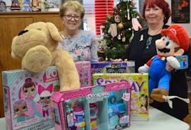 Diane Parlee, left, and Wanda Earhart sort through toys received at Every Woman's Centre in Sydney for its annual adopt-a-family program. Each year, the program helps about 600 families in need have a brighter holiday season.