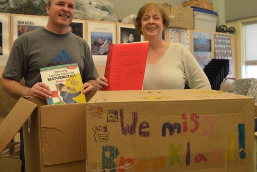 From left, Geoff Oliver and Joyce Lively are seen unpacking books at Brookland Elementary School in Sydney on Wednesday. Students have not attended classes in the school since a Thanksgiving Day storm caused major damage to the building. Close to 330 students are expected to return to the school today, depending on the weather.
