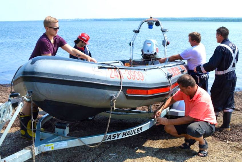 John Chant, right, fire chief of the Glace Bay Volunteer Fire Department, helps members of the fire department’s water rescue unit Ryan Orr, from left, Steven MacNeil, Kenny Routledge and Gerry Bennett secure the rescue boat after responding to what was believed to be a swimmer in distress in Lingan bay in River Ryan on Tuesday. A New Waterford man in his 60s was discovered to simply be taking one of his annual swims across the bay.
