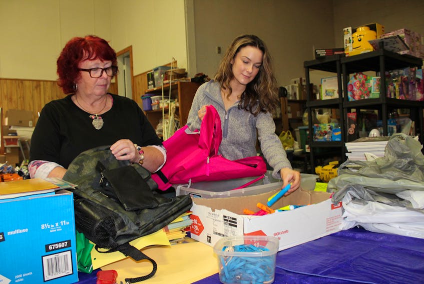Wanda Earhart, left, and Bhreagh Unsworth sort donations that have been received at the Every Woman’s Centre in Sydney, for its annual back to school program. It is an income-based program that helps provide up to 500 children annually with some of the supplies they require when heading back to school.