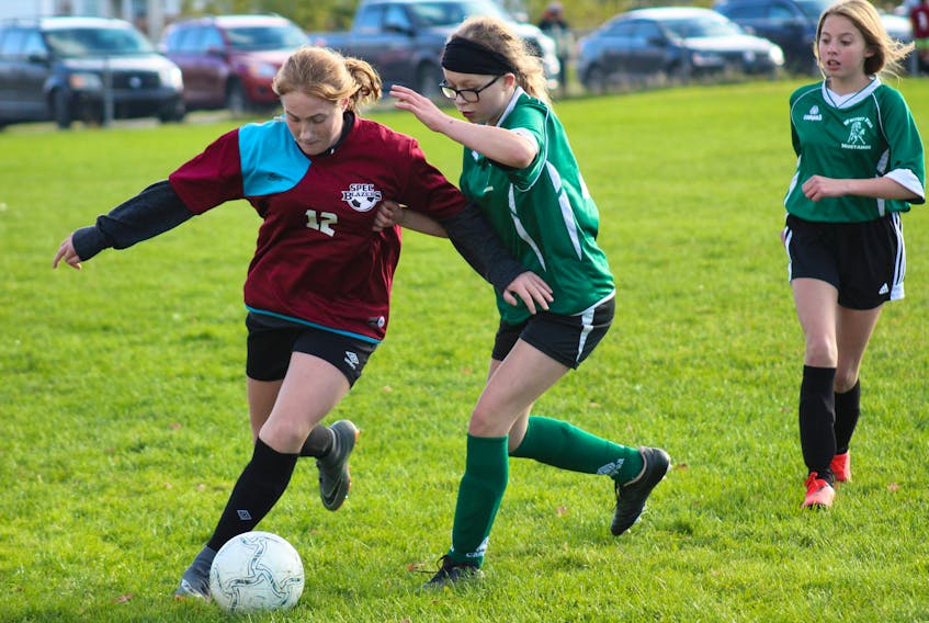 From left, Beth MacInnis of the SPEC Blazers is pressured by Brooklyn Woodill of the Whitney Pier Mustangs while Ella Oakley of the Mustangs looks on during Cape Breton Middle School Soccer League girls ‘B’ playoff action Tuesday at Neville Park in Whitney Pier. T.J. COLELLO/CAPE BRETON POST