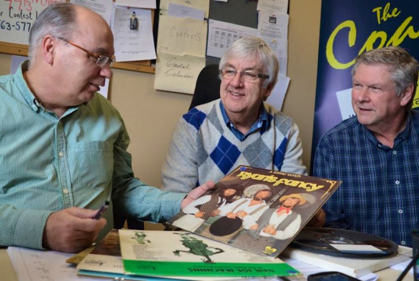 Donnie Campbell, centre, host of Celtic Serenade show, looks over some of his old folk records with Bill MacNeil, left, general manager of The Coast 89.7, and Phil Thompson, program director. After more than 40 years with CJCB, Campbell is continuing his ‘Celtic Serenade’ show on The Coast.