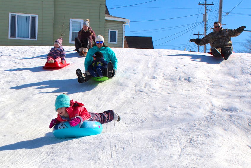 Six-year-old Rachel Doyle takes the lead as she sleds with her parents, brother, cousin and aunt at Ashby Corner in Sydney on Sunday. The family was happy to be enjoying the sunny skies, mild temperatures and good sliding conditions. Middle, from left, two-year-old Aubreigh Doyle, her aunt Dawn Spracklin with her two-year-old son Ryan Doyle; back, from left, Aubreigh's mother Danna Martin and her uncle, Ryan and Rachel's father, Terry Doyle.