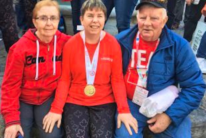 ['Aimee Gordon, centre, is pictured with her aunt Frances Gordon and father Alex Gordon after winning the gold medal in the 500-metre speedskating race at this year’s Special Olympics World Winter Games in Austria on Thursday. Gordon is the first Cape Bretoner to ever win a medal at the games.']