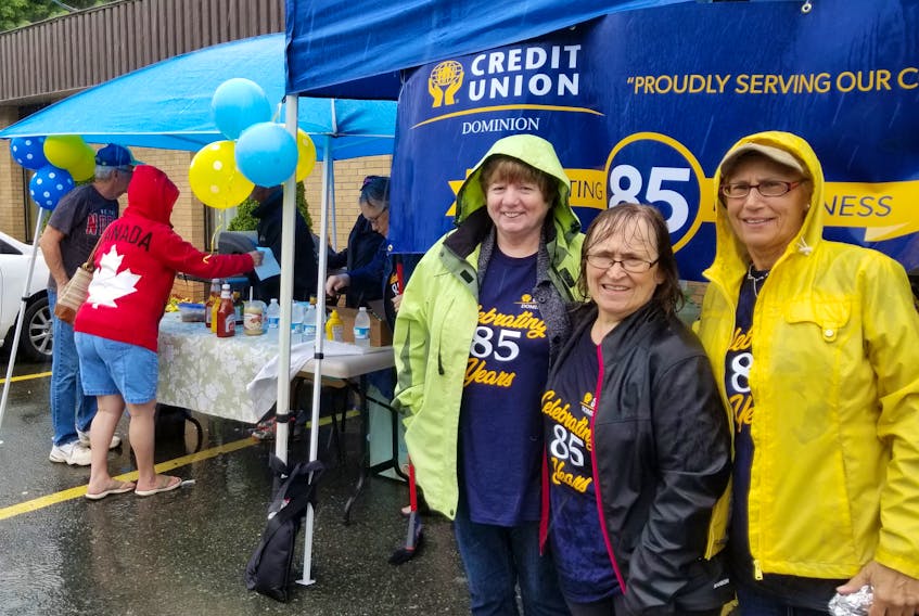 The cold rain didn’t stop credit union board members Loraine Kennedy, Rita Hawco, and manager Rina Gouthro of the Dominion Credit Union from celebrating their 85th Anniversary and venturing out from the safety of their tents. The Dominion Credit Union celebrated the day complete with a free barbecue, with hotdogs, sausages and slushies for everyone to enjoy.