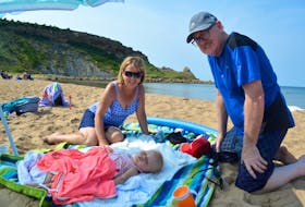 New Waterford residents Theresa Donovan, left, her husband, Patrick Donovan, right, and their sleeping granddaughter, Sylvie Drescher   enjoyed the day at Chimney Corner beach on Aug. 28. Sale of the property, which includes the beach and 37 acres of the land into the water, has the Donovan’s worried they won’t be able to enjoy the beach anymore.