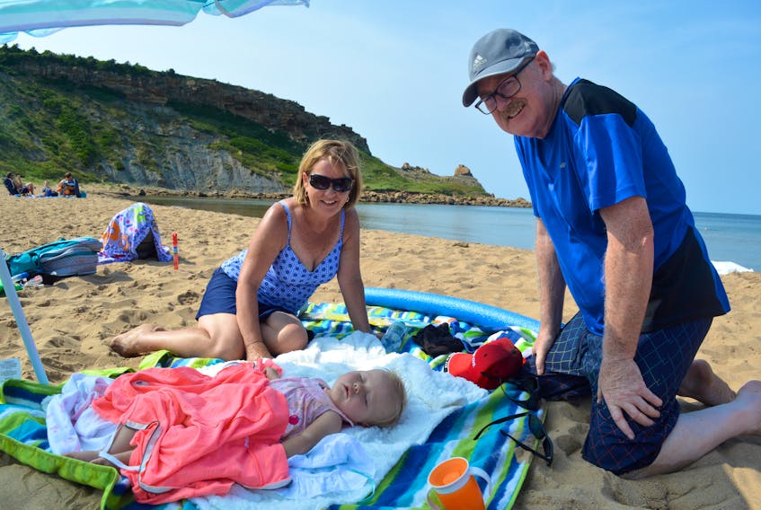 New Waterford residents Theresa Donovan, left, her husband, Patrick Donovan, right, and their sleeping granddaughter, Sylvie Drescher   enjoyed the day at Chimney Corner beach on Aug. 28. Sale of the property, which includes the beach and 37 acres of the land into the water, has the Donovan’s worried they won’t be able to enjoy the beach anymore.