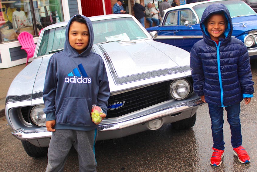 Maliki Lawrence, 8, left, and his younger brother Latrell, 6, braved steady rainfall Saturday to check out some of the antique cars on display as part of the Cape Breton Classic Cruisers show and shine on Charlotte Street.