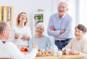 Group of happy seniors laughing together at a meeting in this stock photo.