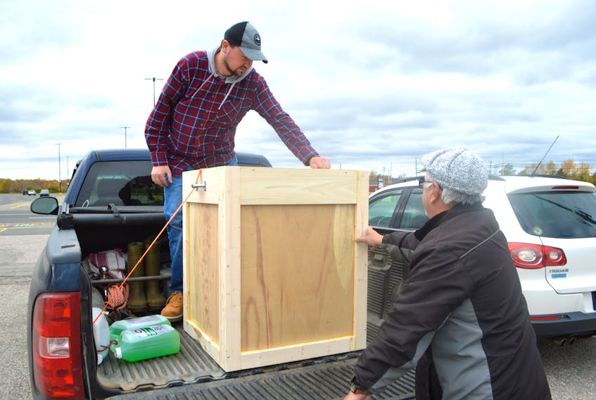 Jeff McNeil, left, and Stan Peach of the Port Morien Wildlife Association secure a wooden crate holding the carcass of a bald eagle provided by the Nova Scotia Department of Lands and Forestry. The association will use the eagle carcass to educate the public on the dangers of lead ammunition and tackle as well as Mi’kmaq culture and beliefs. The carcass will be blessed during a ceremony Friday at 11 a.m. in Membertou.