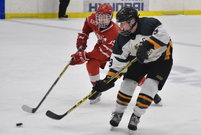 Eldon Snow of the Memorial Marauders, right, is checked by Dustin Sudds of the Riverview Redmen during Cape Breton High School Hockey League play Thursday at the Emera Centre Northside in North Sydney. Snow scored a hat trick as Memorial won, 6-1. T.J. Colello/Cape Breton Post
