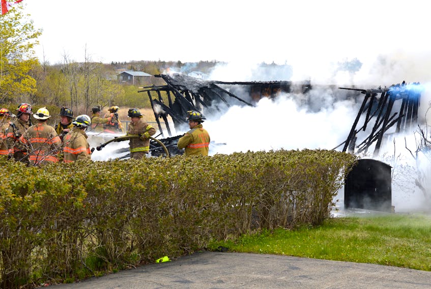 Members of the Glace Bay and Reserve Mines volunteer fire departments battle a garage fire at 34 Quarry Rd. that broke out late Thursday morning. The fire destroyed the garage and caused damage to two houses.