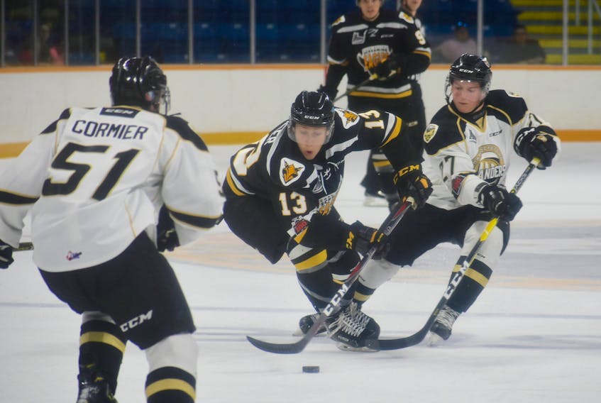 Shaun Miller, middle, of the Cape Breton Screaming Eagles carries the puck into the offensive zone as he’s pressured by Sydney native Derek Gentile, right, of the Charlottetown Islanders during Quebec Major Junior Hockey League preseason action at Centre 200 on Friday. The Screaming Eagles won the game 5-3.