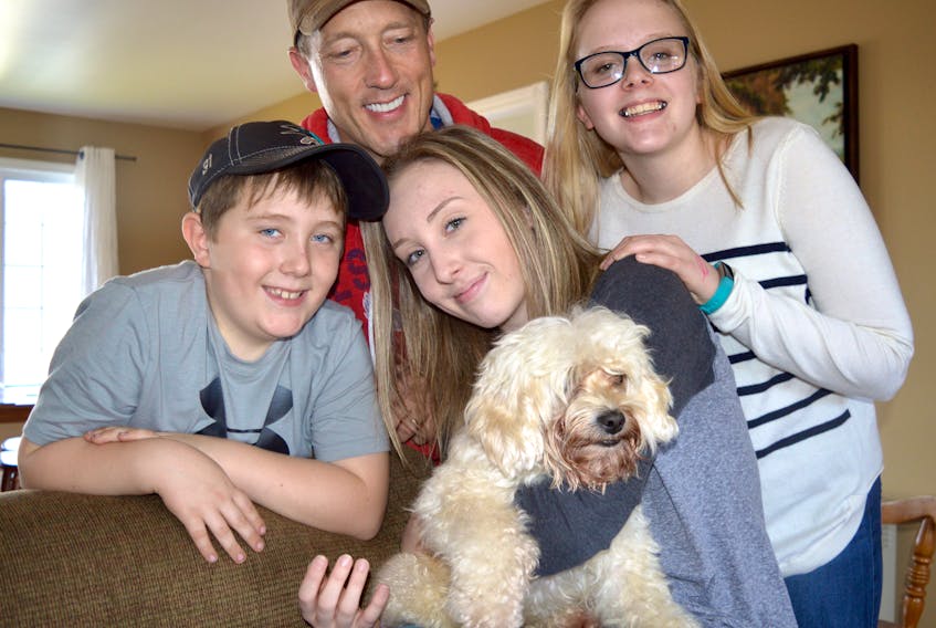 Jerome Kelly, in back, and his children, from left, Bryden, 8, Brooke, 15, and  Breagh, 13, enjoy an emotional reunion with their four-year-old cockapoo Jak on Tuesday after he was missing for nine days after escaping during a trip to the dog groomer in Sydney.