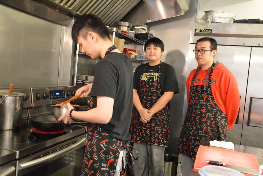 Wei Fan Duan, back left, and Chen Yu Yao stand behind cook, Lendi, at the Bai Wei restaurant on Townsend Street in Sydney. The new eatery promises authentic Chinese food and specialty dishes like grilled quail and marinated pork stomach. NIKKI SULLIVAN/CAPE BRETON POST