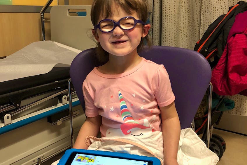 Norah Cameron-Ranni, 3, waits at the Hospital for Sick Children in Toronto for her cornea transplant surgery. Staff gave her an iPad to keep her happy since she was too nervous to go to the playroom.