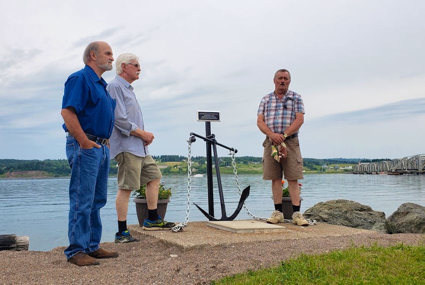(From left) Billy MacKinnon, Hugh MacNeil and Michael Angus MacKinnon, all captains who worked on the Barra Strait ferry service before it shut in 1993, stand beside the new anchor and plaque unveiled at on July 21. Former captains missing from the photo are Joe Burke, David MacNeil, Gail MacNeil, Arnold MacNeil and Albert MacKinnon.