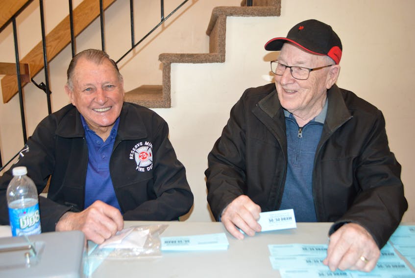 Wilfred Doucette, left, and Rickey Hinchey, members of the Reserve Mines Volunteer Fire Department, sell 50/50 fundraiser tickets at the Tompkins Centre on Sydney Road in Reserve Mines. Doucette said he doesn’t think Cape Breton-Canso MP Rodger Cuzner should retire because he thinks he’s doing a good job. Cuzner officially announced his retirement Friday.
