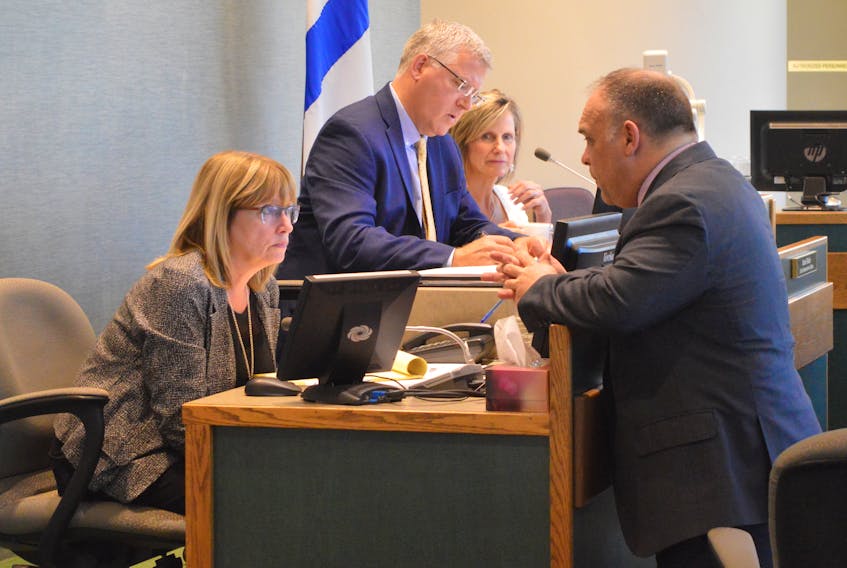 CBRM Mayor Cecil Clarke takes notes while senior municipal staff discuss a technical point during a debate on a proposed doggy daycare facility during Tuesday evening’s council meeting at city hall. Shown above, from left, municipal clerk Deborah Campbell-Ryan, Clarke, chief administrative officer Marie Walsh and CBRM solicitor Demetri Kachafanas.