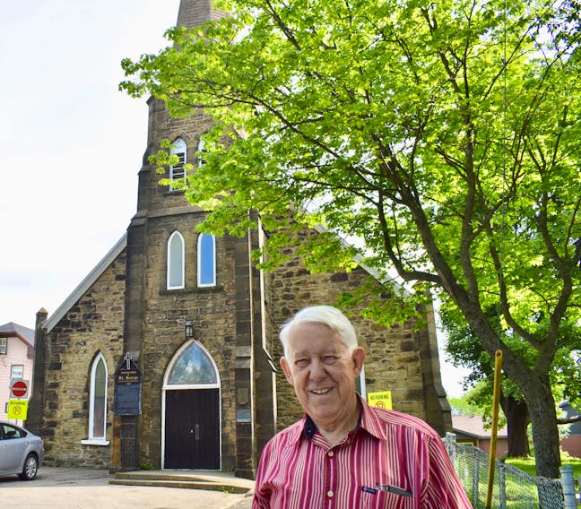 Organist and choir director Jim McNeil stands in front of St. George’s Church, the oldest building in Sydney. McNeil’s choir, Coro Cantabile, and the Viva Chorale from B.C. will hold a fundraising concert at the church on July 7.