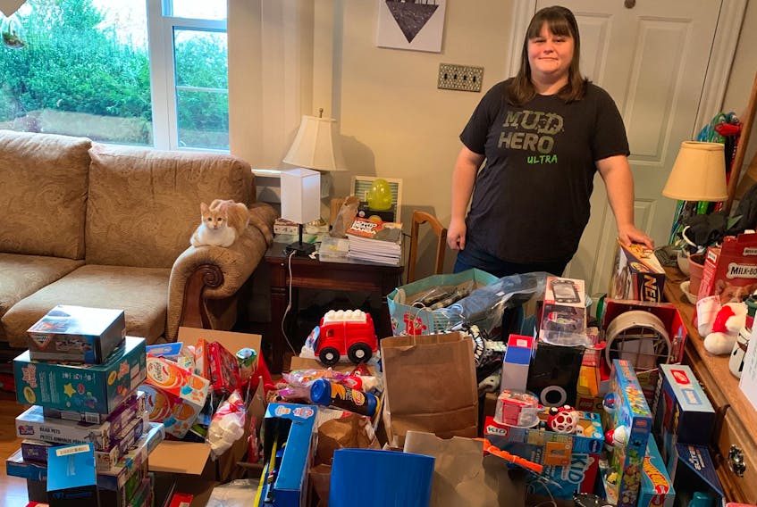 Social worker Nicole Stevenson stands among the toy donations she's collected in her free time for an Adopt-a-Family campaign she started this year due to her seeing an increased number of families in need this Christmas season due to the COVID-19 pandemic.