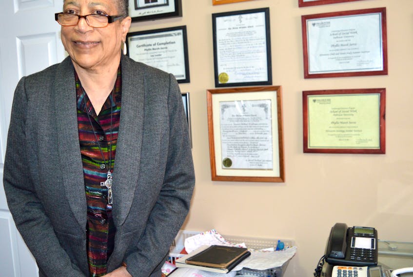 Rev. Phyllis Marsh stands in her office beside the numerous certifications she has for training in programs that help improve communities and for her ordination as a reverend in 2015. Marsh was the first African-Canadian woman to become an ordained priest in the country.