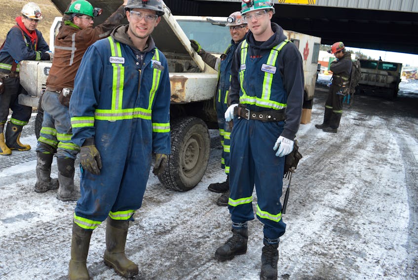 Shamus MacDougall, left, 25, of Donkin, a training miner operator at Donkin mine, chats with Wyatt Scheller, 25, of Lingan, a roof bolt operator, while preparing to get in the personnel carrier with the rest of their crew for transport into the mine, about a 3.5-km under the ocean. The mine celebrated the first anniversary of coal production Tuesday.