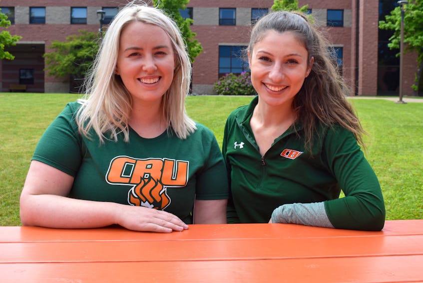 Kayla Walzak, left, and Becky Hanna sit in the courtyard at Cape Breton University. They are the lead coaches for Capers in the Community, a series of free four-day activity camps that will travel to 12 communities to teach kids fundamental movement skills. Chris Connors/Cape Breton Post