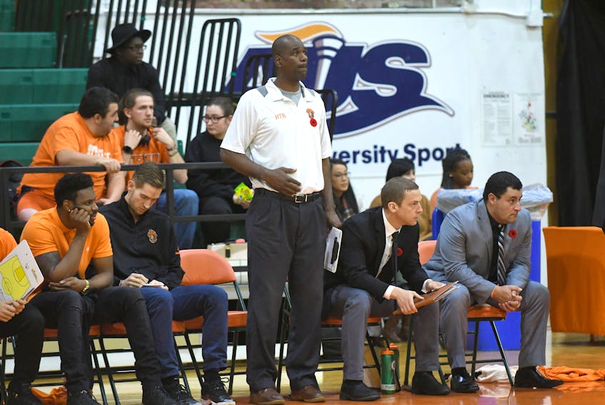 Shaun Robinson stands in front of the Cape Breton University Capers bench in this recent photo. Robinson, who won back-to-back conference banners with the team in the 1990s, is back as an assistant coach. Vaughan Merchant/Cape Breton University