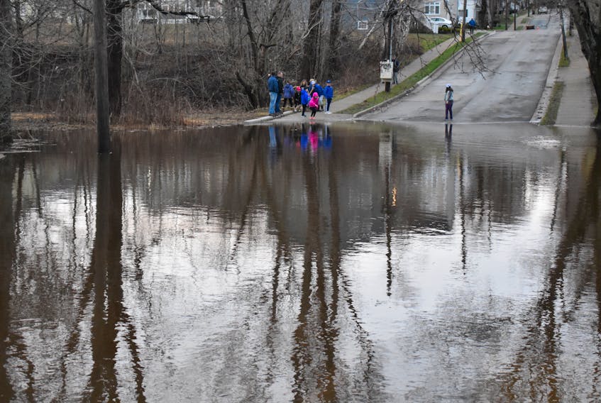 A group of local residents checks out the flooding on St. Peters Road in Sydney in this file photo from Sunday, April 29. The waters of the Wash Brook reached its highest levels since the devastating flooding on the Thanksgiving weekend in 2016. Much of the same area was affected, with some of the now-homeless properties once gain submerged by the same flood waters.