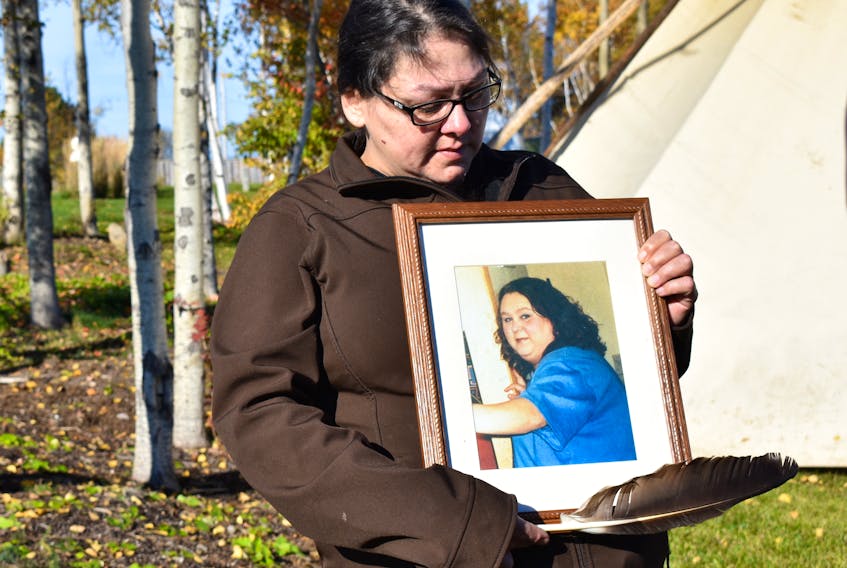Tricia Johnson holds a picture of her late sister, Cheryl Ann, during the opening ceremonies for the national inquiry into missing and murdered Indigenous women and girls, which takes place in Membertou from today until Wednesday.