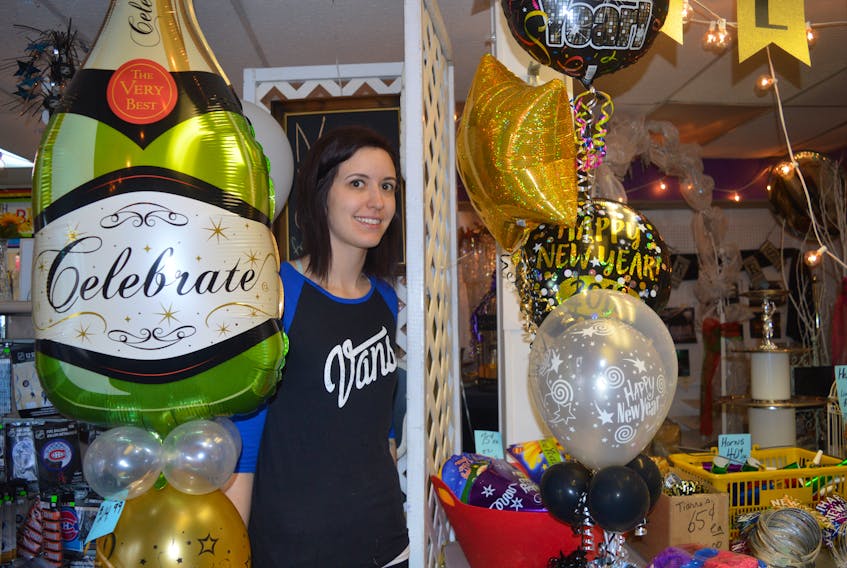 Tiffany Smith, an employee of Walter’s Party Rentals in Sydney, is shown with some of the more popular New Year’s Eve party supplies for this year. GREG MCNEIL/CAPE BRETON POST