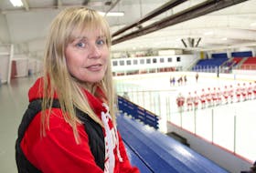 Lisa MacDonald sits in the stands at the Cape Breton County Recreation Centre at the start of the Riverview Redmen's exhibition game or charity against former players on Saturday. She is one of many parents who are concerned changes to Riverview High School's annual Red Cup Showcase will have negative impacts on the tournament.