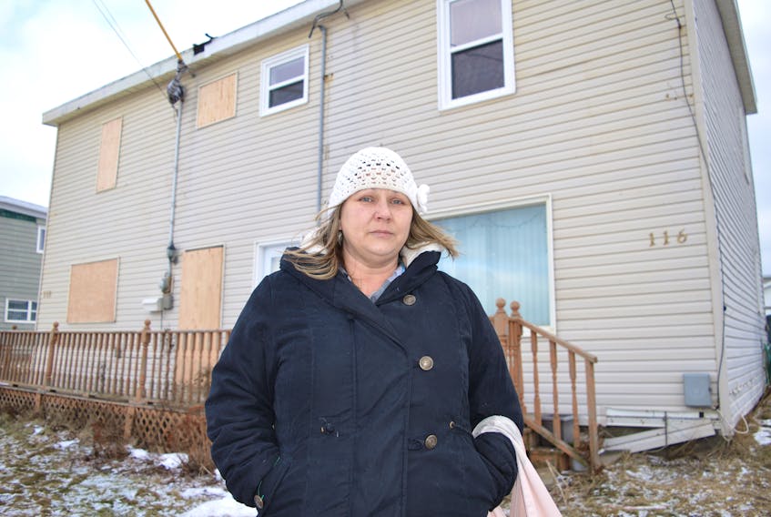 Kimmy Losier stands outside her half of a company house on 116 Fifth St., Glace Bay. Company houses in Cape Breton were typically built for two families, each living in identical units, one left and one right. Losier said the owners of the other side died and relatives moved in and neglected repairs before abandoning the unit in early January after it deteriorated. Since then, water pipes have burst in the walls, severely damaging her side. Losier said she always did repairs and kept up her unit and now she needs help as the abandoned unit is ruining her home.