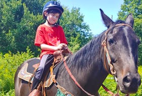 Eight-year-old Kaellum MacDonald of Florence loves to care for his horse Ebony.