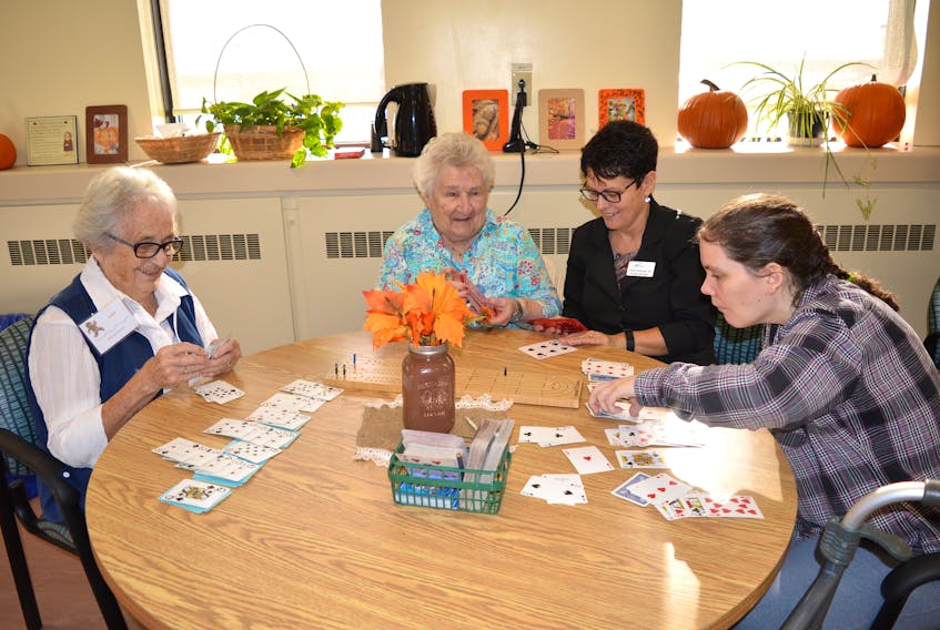 Barbara MacDonald, from left, of Glace Bay, a participant at the adult day program at the Glace Bay Hospital plays cards along with Alena Giovannetti of Reserve Mines, Sheila Prendergast, facility manager, and Karen May of Glace Bay, during an open house last week. Sharon Montgomery-Dupe/Cape Breton Post