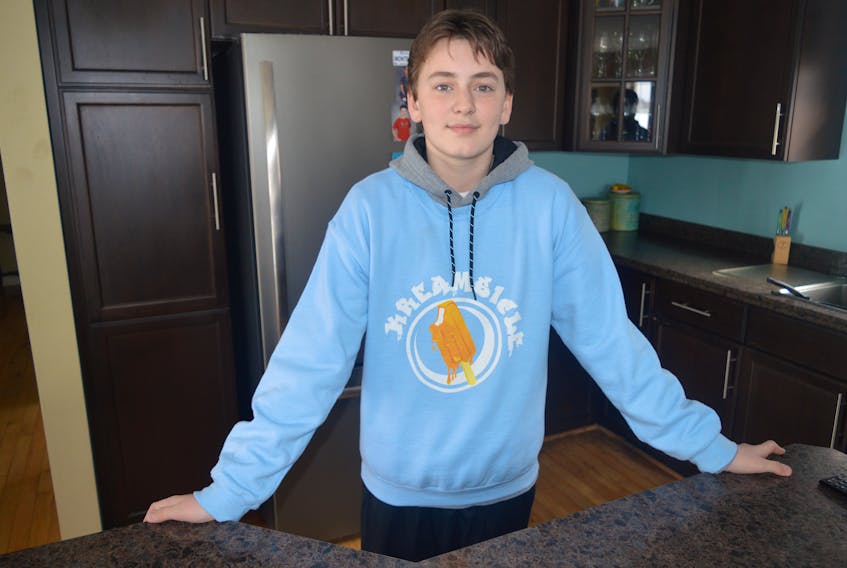 Aidan Hanson shows off one of his hoodies that are sold on his merchandise website for his ‘Kreamsicle’ apparel line. The budding entrepreneur launched his business about six weeks ago from his Albert Bridge home.