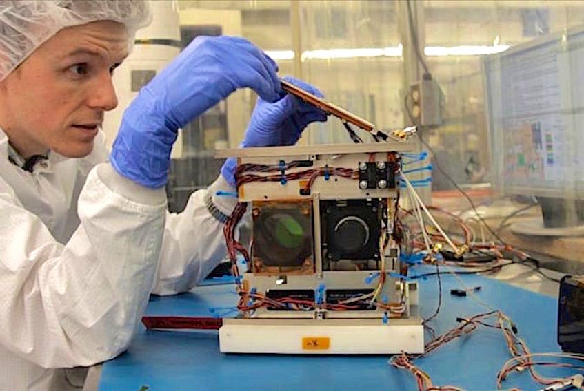 Cordell Grant assembles a nanosatellite at the University of Toronto Institute for Aerospace Studies in 2013.