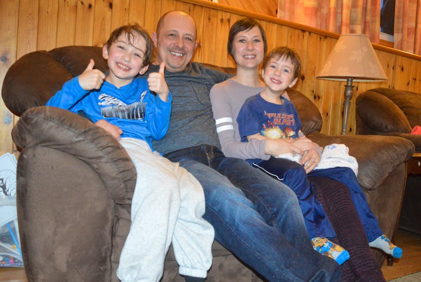Janine Parsons, a cancer survivor, sits with her family at her Sydney River home. On her lap is her four-year-old son, Matthew Thorne, next to her is her partner, Shaun Thorne, and their oldest, Travis, 8, sits next to him. Parsons was able to do all her cancer treatments and medical appointments at the Cape Breton Cancer Centre, which she is grateful for.