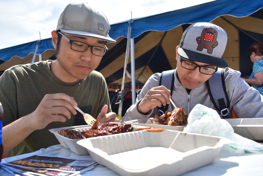Adam Le Hoantran, left, and Nam Ho are shown as they enjoy some ribs from Crabby’s BBQ during the opening day of Sydney Ribfest at Open Hearth Park in Sydney. Le Hoantran and Ho, who are both attending Cape Breton University, have never taken part in Ribfest until Friday and plan to return again this weekend for more delicious ribs.