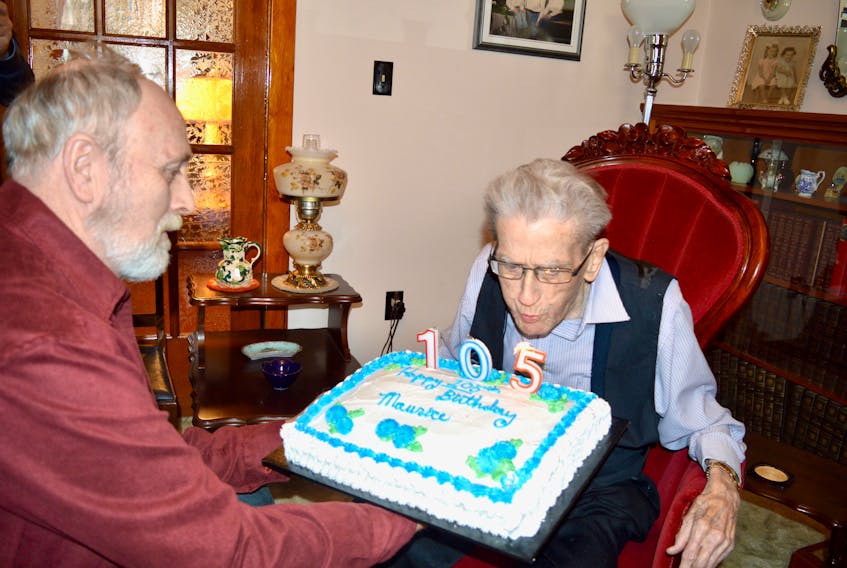 Maurice Bidart has no trouble blowing out his candles while his son Geoffrey holds the cake to celebrate Bidart’s 105th birthday in Sydney on Friday.